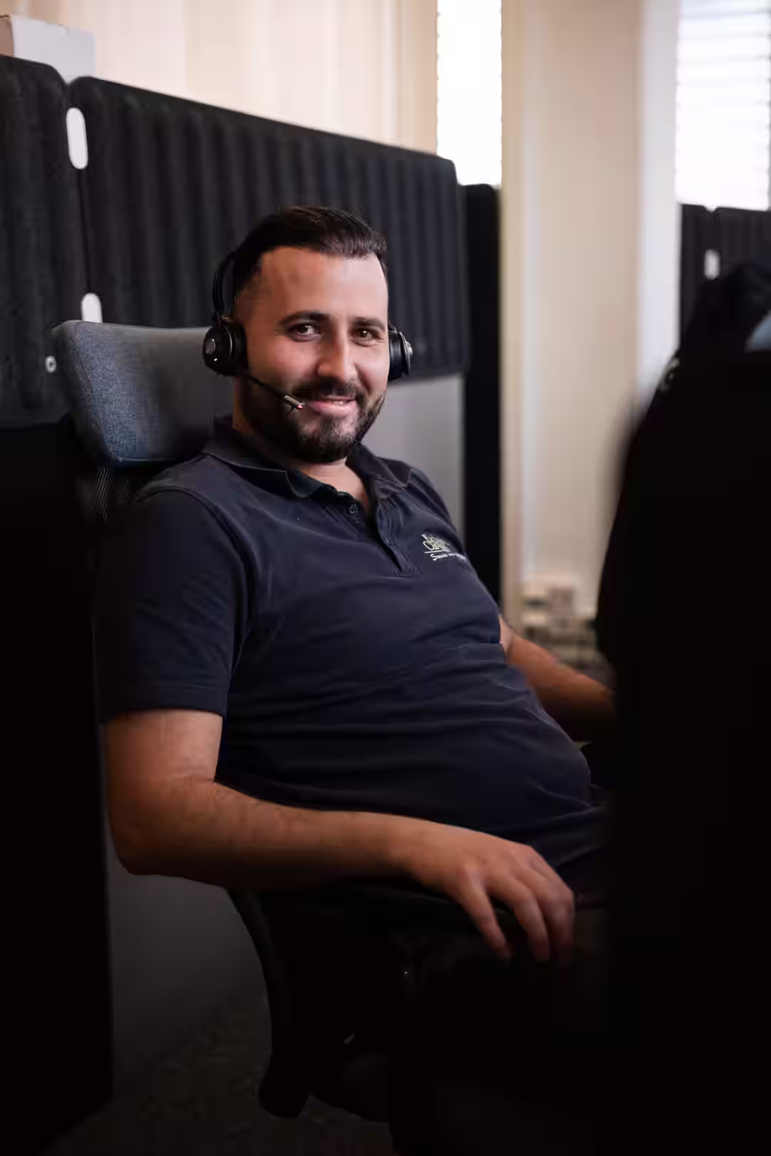 Service Mitarbeiter von Exclusiv Car-HiFi mit Headset an Schreibtisch